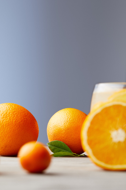 ripe oranges and glass of juice on wooden surface - Φωτογραφία, εικόνα
