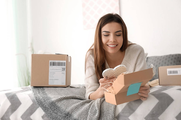 Young woman preparing parcel for shipment to client at home - Foto, imagen