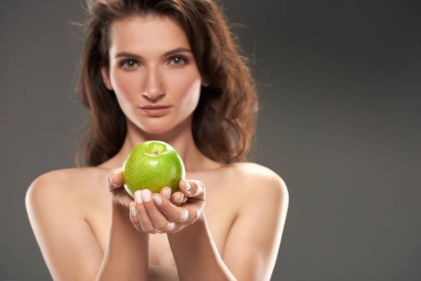 обнаженная девушка со свежим зеленым яблоком, изолированная на сером
 - Фото, изображение
