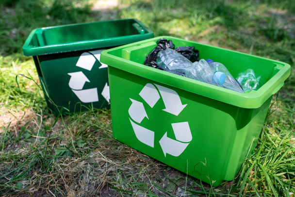 green recycling boxes with plastic trash standing on lawn - Photo, Image