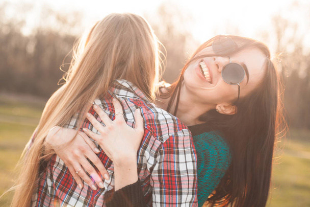 Two best friends having fun and hugging outdoors at sunset. Close up - Foto, Imagem