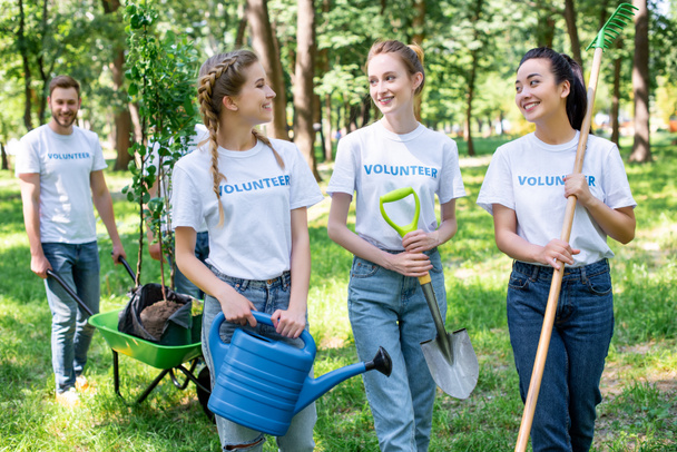 jonge vrijwilligers kijken elkaar in park  - Foto, afbeelding