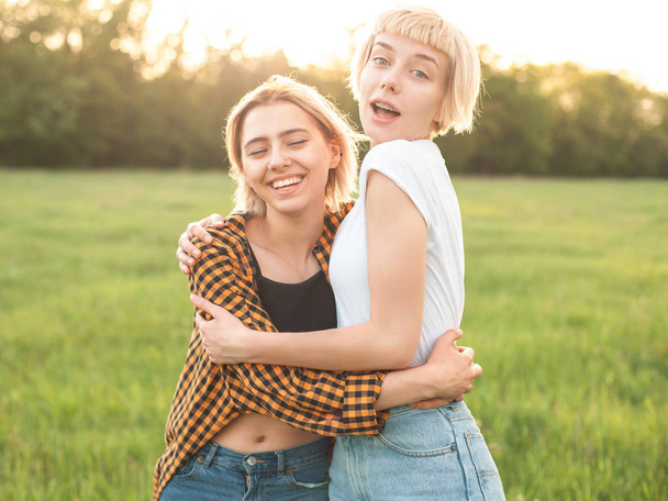 Two young women having fun on the green field. Best friends - Fotó, kép