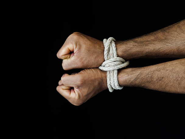 Las manos de los hombres estaban atadas con una cuerda. Violencia, aterrorizado, concepto del Día de los Derechos Humanos
. - Foto, Imagen