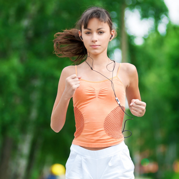 Teenage girl running in green park - Foto, Imagen