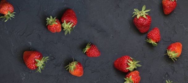 strawberries on the black background. Strawberry on dark chalkboard with copy space.Top view point. - Photo, Image