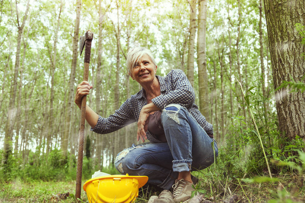 experienced female lumberjack while visiting a forest before cutting some trees - Foto, Imagen