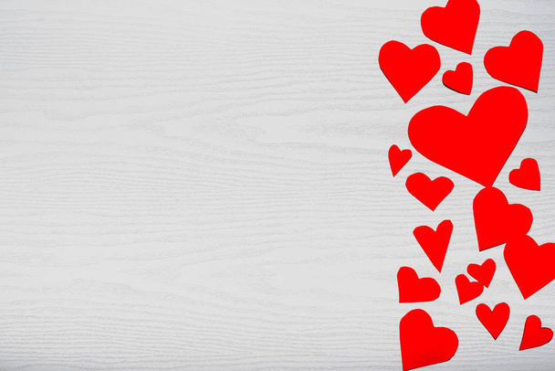 Ξύλινο λευκό φόντο με κόκκινες καρδιές. Η έννοια της ημέρα του Αγίου Βαλεντίνου. - Φωτογραφία, εικόνα