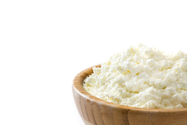 Fresh cottage cheese in a wooden bowl isolated on white background. Copyspace - Zdjęcie, obraz