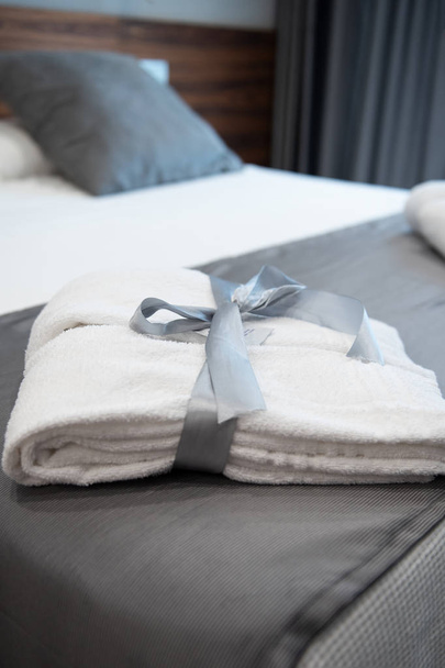 Župan na posteli v hotelovém pokoji světlé luxusní - Fotografie, Obrázek