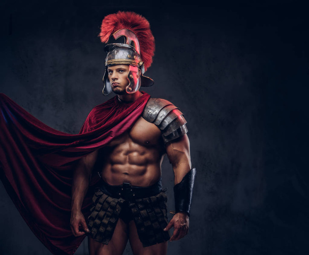 Porträt eines brutalen römischen Legionärs in Kampfuniformen auf dunklem Hintergrund. - Foto, Bild