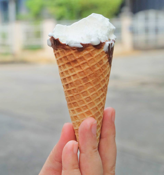 Ruční hospodářství vanilková zmrzlina s čokoládou a matice v oplatkovém kornoutku. - Fotografie, Obrázek