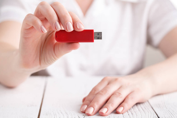 Female hold flash drive in hand on white table - Photo, Image