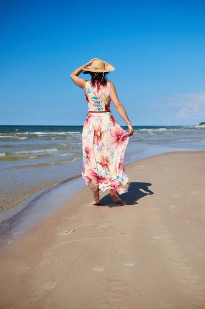 Relaxed girl with a hat is walking on the beach. Baltic Sea Coast, Latvia. - Valokuva, kuva