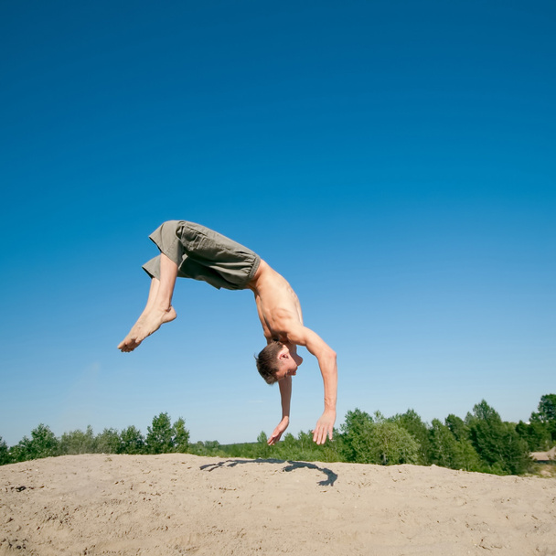Excited young man jumping in air - 写真・画像