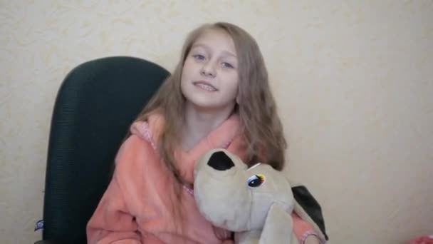 petite fille blonde dans une robe de chambre rose assis sur le canapé raconte émotionnellement
 - Séquence, vidéo