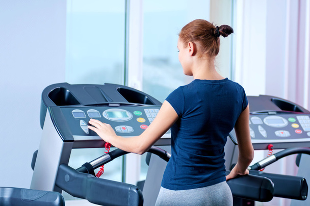 Young woman at the gym run on on a machine - Foto, Bild