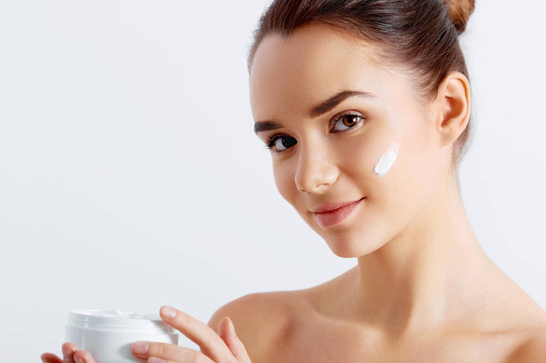 Beautiful woman tender jar of moisturizer cream. Close-up fresh young woman face. isolated on white - Φωτογραφία, εικόνα