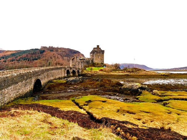 Přílivu a odlivu v jezeře na hrad Eilean Donan, Skotsko. Most přes suché mořské řasy - Fotografie, Obrázek