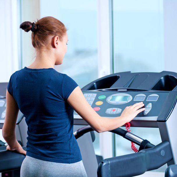 Young woman at the gym run on on a machine - Foto, imagen