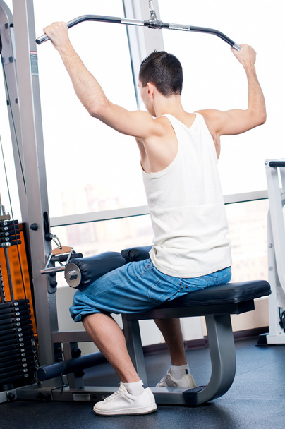 Young man doing exercises at gym - Valokuva, kuva