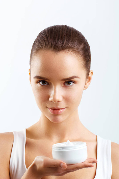 Face Skincare. Woman with healthy smooth facial clean skin holding bottle cream.Beauty face care.Facial treatment.Cosmetology.Beauty and Spa.  - 写真・画像