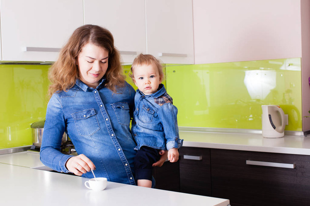 Anne kahve yapma ve onun bebek tutan - Fotoğraf, Görsel