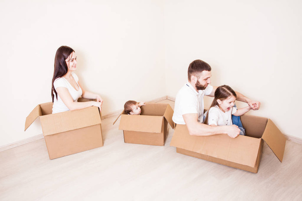 Moving house day and family games in cardboard boxes at new home - Foto, immagini