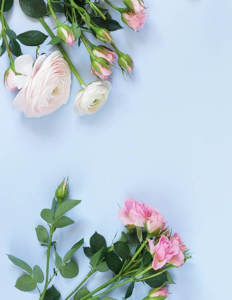 Flowers background. Bouquet frame of pale pink ranunculus and roses flowers on pale blue background. - Fotografie, Obrázek