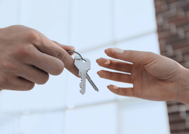 Cropped image of estate agent giving house keys to man in office - Foto, Bild