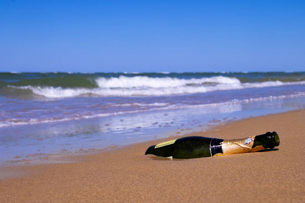 Pusta butelka szampana został zabrany przez burzę do brzegu - Zdjęcie, obraz