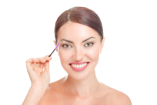 Beautiful woman lady, holding mascara brush near her long eyelashes. Isolated white background with copy space. Positive face expression, toothy smile, happy girl - Φωτογραφία, εικόνα