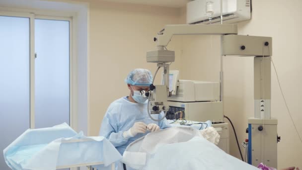 Tylko chirurg siedzi w sali operacyjnej w pobliżu tabeli z pacjentem - Materiał filmowy, wideo