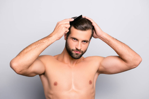Close up portrait of virile attractive modern handsome muscular brunette combing his perfect ideal thick hair in front of the mirror isolated on gray background copy-space - Фото, изображение