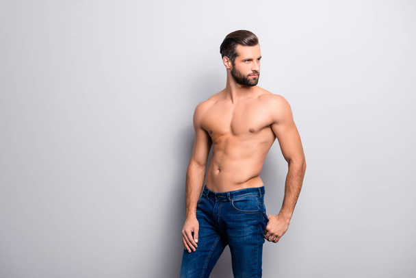 Beard bristle stubble. Portrait of handsome hot sexual strong tempting guy with perfect hairstyle, casual denim jeans holding hands in back pocket looking aside isolated on gray background copy-space - Foto, afbeelding