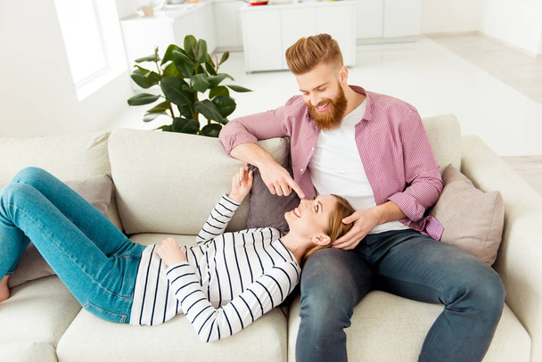 Look romance chill wife husband vacation weekend holidays concept. Handsome peaceful cheerful stylish trendy guy and beautiful cute lovely joyful girl having a rest in new flat lying on beige divan - Fotó, kép