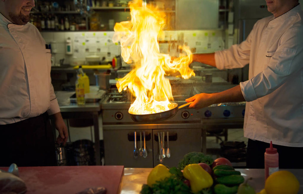 Шеф-повара делают фламб на еду
 - Фото, изображение