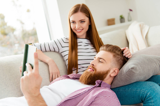 Leisure lifestyle gentle partners dream dreamy chat talk conversation care trust concept. Handsome lovely careful cute excited cheerful guy reading love story to his adorable lady lying on her legs - Photo, image