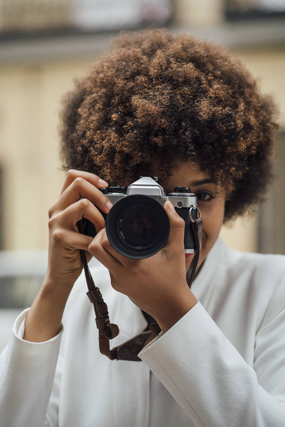 Female photographer visiting Madrid with an old analog camera. Afro race young woman, 21 years old. - Foto, immagini