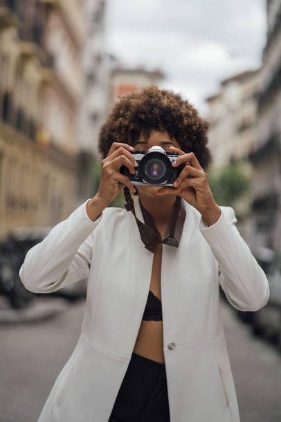 Female photographer visiting Madrid with an old analog camera. Afro race young woman, 21 years old. - Foto, Bild