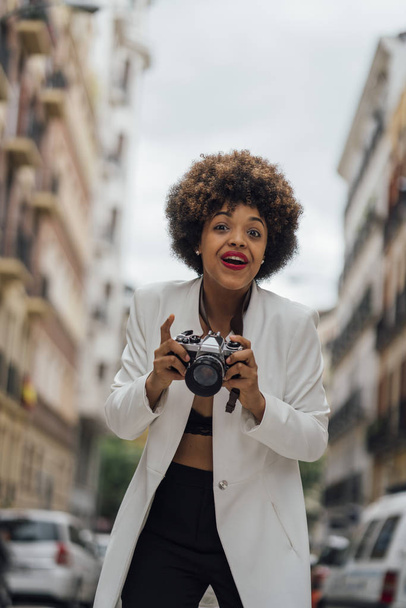 女性写真家は、古いアナログ カメラでマドリードを訪問します。アフロ レース若い女性、21 歳. - 写真・画像