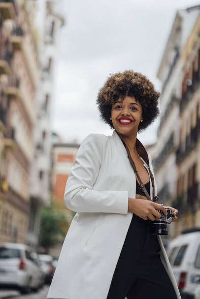 Naisvalokuvaaja vierailee Madridissa vanhan analogisen kameran kanssa. Afro race nuori nainen, 21 vuotias
. - Valokuva, kuva