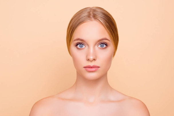 Portrait of cute lovely girl with soft smooth perfect skin plump lips big eyes looking at camera isolated on beige background. Wellness wellbeing concept - 写真・画像