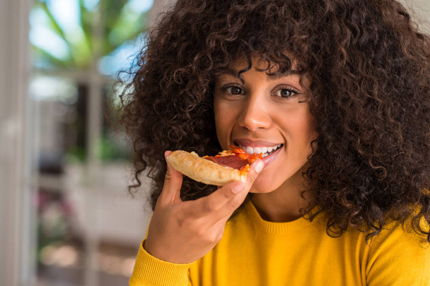 Afroamerické ženy připravené k jídlu pepperoni pizza plátek s výrazem věří na inteligentní tvář myslí vážně - Fotografie, Obrázek