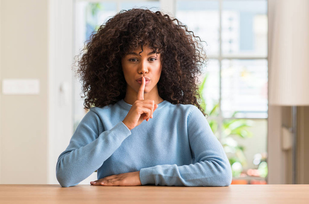 Afrikalı-Amerikalı kadın evde dudaklarında parmak ile sessiz olmanı. Sessizlik ve gizli kavramı. - Fotoğraf, Görsel