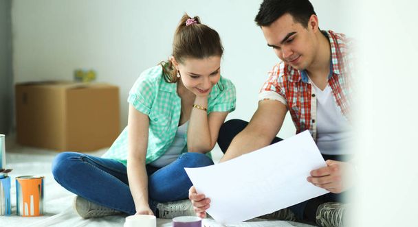 Young couple sitting on floor and calculating about they savings - Foto, immagini