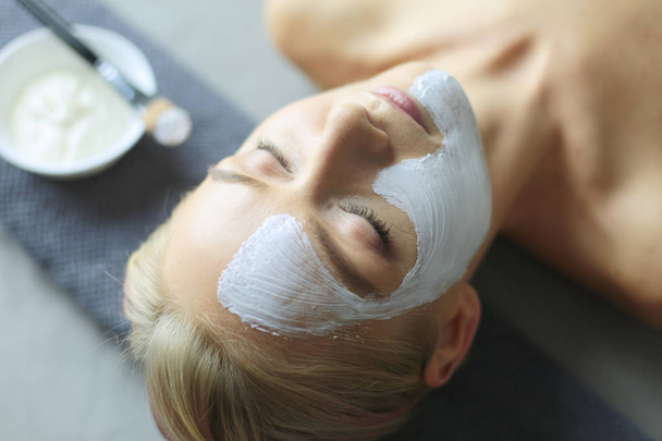 Face mask.Beautiful young girl at spa ,cosmetician woman applying facial mask. - Foto, Imagem
