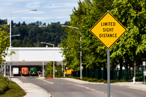 Rajoitettu Sight Distance merkki tiellä puiden ja perävaunujen kanssa
 - Valokuva, kuva