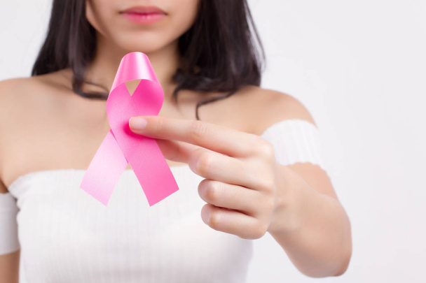 nő kezében, rózsaszín szalag íj, mell rák tudatosság szimbólum, mell rák nap; orvosi, jótékonysági pénzgyűjtés koncepció mell rákos beteg vagy megelőzésére rózsaszín szalag - Fotó, kép