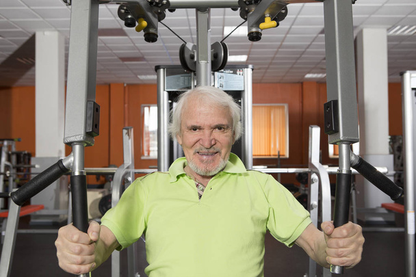 Älterer Mann mit Bart und Schnurrbart im Fitnessstudio, der mit Gewichten trainiert - Foto, Bild